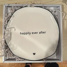 a white plate with the words happily ever after written on it and someone standing next to it