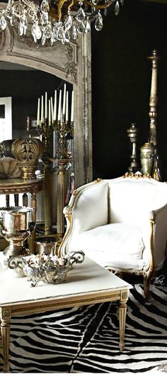 a white couch sitting in front of a mirror on top of a wooden table next to a zebra print rug