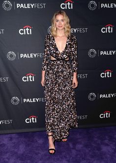 a woman in a floral dress standing on a purple carpet at the palefest festival