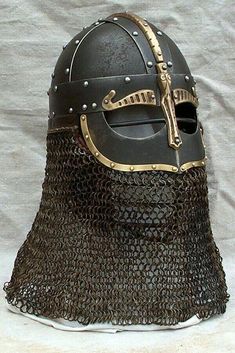 a helmet that is sitting on top of a white sheet with chains attached to it