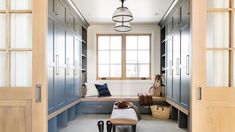 an empty room with lots of blue cabinets and drawers on the wall, in front of a window