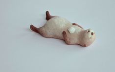 a small toy animal laying on top of a white surface