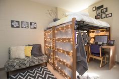 a loft bed with lights on it and a desk in the corner next to it