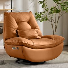 a brown leather recliner chair sitting on top of a rug next to a potted plant