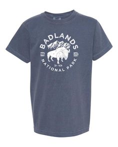 The Badlands National Park Comfort Colors tshirt design features the iconic Bison that reside in the park. It is printed with white environmentally friendly water based ink on a Comfort Color garment dyed T-shirt. These shirts are relaxed fit and midweight.Comfort Color garment dyed T Shirts are inspired by nature. Special attention is given to the pigment‑dyed color process for a perfect vintage look every time. Garment dyed t-shirts experience less shrinkage and make for a more comfortable fee Outdoor Soft-washed Short Sleeve T-shirt, Soft-washed Relaxed Fit T-shirt For Outdoor, Outdoor Graphic Tee Soft-washed, National Park Design, Mountain Shirts, Park Design, Badlands National Park, Comfort Colors Tshirt, Family Vacation Shirts