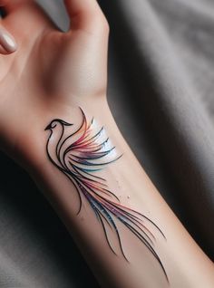 a woman's arm with a colorful bird tattoo on the left side of her wrist