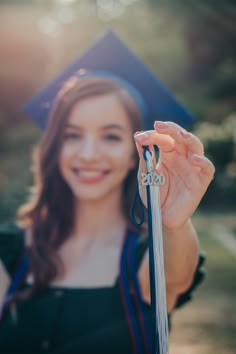 a woman in graduation cap and gown holding up a keychain