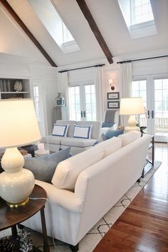 a living room filled with furniture and two lamps on top of each other's tables