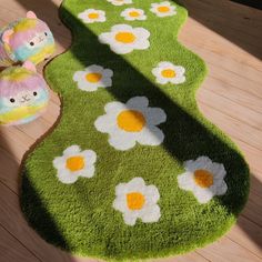 two stuffed animals sitting on top of a green rug next to a flowery carpet