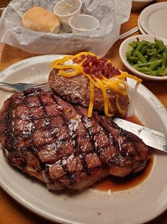 a steak and green beans on a white plate