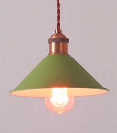 a green lamp hanging from a ceiling with a light bulb on it's side