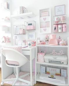 a white desk topped with lots of pink items next to a shelf filled with books