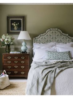 a bedroom with green walls and white bedding