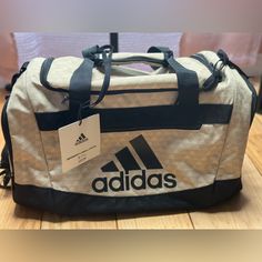 Prepare For The Day And Ensure You Have All Of Your Essentials Packed With This Adidas Defender Iv Small Duffel. Product Features Transition From Work To The Gym With Ease. This Newly Updated Duffel Bag Features Extra Pockets To Stash The Essentials, And Padded Shoulder Straps Let You Move In Comfort. Product Details Imported Zipper 11.75" X 11.0" X 20.5 " Cu In. Manufacturer's Lifetime Limited Warranty. For Warranty Information Please Click Here Polyester Casual Beige Bag With Logo, White Travel Shoulder Bag With Embossed Logo, White Shoulder Bag With Embossed Logo For Travel, Sporty Everyday Shoulder Bag With Logo, Functional Adidas Gym Bag For Travel, Sporty Rectangular Bag With Logo, Adidas Functional Travel Bag, Functional Adidas Travel Bag, Sporty White Bag With Logo