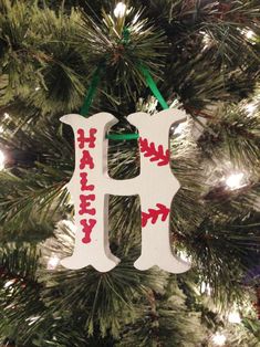 a wooden ornament hanging from a christmas tree with the letter h on it