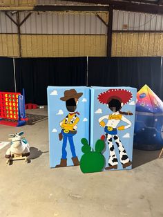 two refrigerators with cartoon characters painted on them in an indoor area next to a toy car