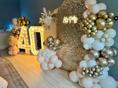 balloons are arranged in the shape of letters and numbers, along with lights on the wall