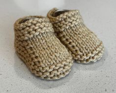 a pair of crocheted baby shoes sitting on top of a white countertop