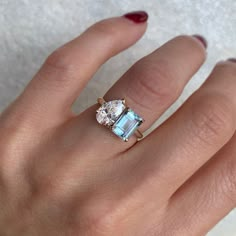 a woman's hand with a ring on it and two stones in the middle