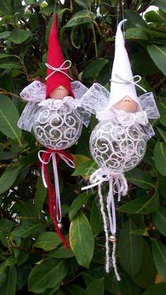 two ornaments in the shape of angels hanging from a tree