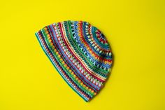 a multicolored crocheted hat on a yellow background