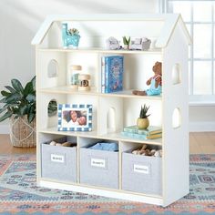 a toy house shelf with toys and books on it