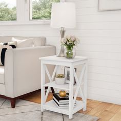 a living room with white furniture and flowers on the table in front of the couch