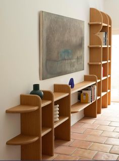 the bookshelves are lined up against the wall in front of the painting on the wall