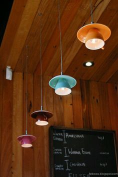 several lights hanging from the ceiling above a chalkboard