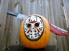 a halloween pumpkin with a mask on it and a knife sticking out of the top