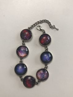 This bracelet is made with blue, red, and white galaxy pictures under glass cabochons, silver colored findings, and silver colored lobster claw clasp. The bracelet has an extender making the bracelet any size between 7-9 inches long. This bracelet is perfect for any sky gazer. If you have any questions or concerns feel free to contact owner and designer at hannahsjeweltique@gmail.com Nickel-free Adjustable Space-themed Jewelry, Adjustable Multicolor Cabochon Bracelets, Galaxy Bracelet, White Galaxy, Pineapple Bracelet, Cameo Bracelet, Galaxy Pictures, Lobster Claws, Starfish Necklace