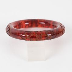 This is part of Chairish’s Costume Jewelry assortment.  Stunning red tea amber marble Bakelite bracelet bangle. Chunky rounded domed shape with a deep floral carving all around. Intense orange-red color with lots of cloudy swirling and translucency. Measurements: Inside across is 2.50 in diameter (6.4 cm) - outside across is 3.63 in diameter (9.2 cm) - width is 0.57 in wide (1.4 cm) - the wall is 0.57 in thick (1.4 cm).  Please see the measurements noted above in the description for the best app Handmade Bakelite Bangle Bracelet, Vintage Red Round Bangle, Luxury Red Bangle, Handmade Round Bakelite Jewelry, Handmade Bakelite Bracelets As Gift, Adjustable Carved Round Bracelets, Luxury Carved Bangle Bracelets, Luxury Carved Bangle Bracelet, Adjustable Carved Bracelets