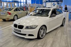 a white car is parked in a showroom