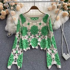 Embrace the art of crochet with this handcrafted green and cream crochet top. This unique piece features intricate floral patterns, meticulously crafted with a blend of green and cream yarns. The open-knit design adds a bohemian touch, perfect for layering over camisoles or bralettes for a chic, laid-back look. The wide, bell sleeves enhance the vintage appeal, making this top a standout addition to your wardrobe.The tops relaxed fit and breathable fabric ensure comfort and versatility, suitable Spring Green Crochet Lace Dress, Bohemian Lace Crochet Top With Open Knit, Green Bohemian Crochet Dress For Spring, Green Crochet Top For Summer, Green Crochet Lace Summer Dress, Green Open Knit Tops For Spring, Green Lace Tops For Spring, Spring Green Crochet Top With Open Knit, Green Long Sleeve Crochet Top For Beach