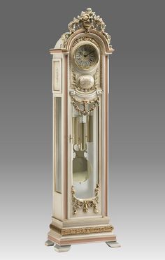 an antique grandfather clock with gold trimmings and ornate decorations on the front side