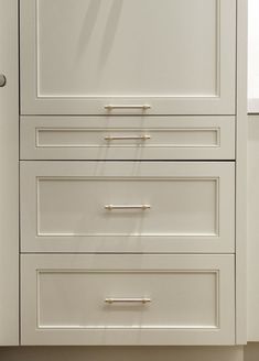 a white cabinet with three drawers in it