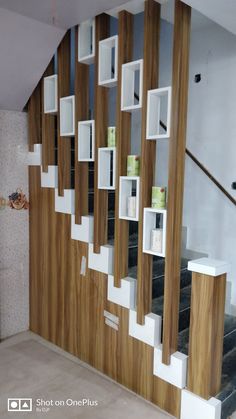 the stairs are lined with wooden shelves and white shelving units on each side, along with bookshelves