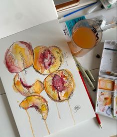 an artist's work with watercolors and paintbrushes on the table