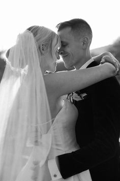 a bride and groom embracing each other in black and white