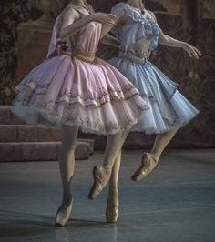 two ballerinas dressed in pink and blue tutues, one is dancing