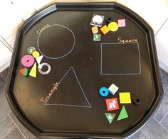 a child's chalk board with different shapes and sizes on the bottom, along with magnets