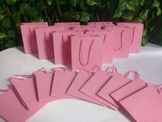 pink paper bags are lined up on a table