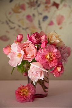 a vase filled with pink flowers on top of a table