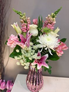 a vase filled with lots of pink and white flowers