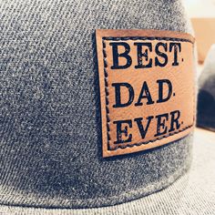 "Best Dad Ever Snapback hat with faux leather patch and thick stitch for added durability and style! You know he's the BEST, so why not show him with one of his favorite things- a hat! Snapback Hats that Dads are sure to LOVE! Show the Dad in your life how much he means to you with these awesome hats! These are stylish and durable to hold up to the Dad life! Adjustable Snapback style. *Richardson 112 style available upon request and made to order so turn around time for that style is about 5-7da Adjustable Snapback Hat With Patches And Flat Brim, Adjustable Trucker Snapback Hat With Letter Patch, Everyday Adjustable Snapback Hat With Letter Print, Flat Bill Baseball Cap With Patches, Adjustable Flat Bill Baseball Cap With Patches, Adjustable Hats With Leather Patch As Gift, Casual Snapback Hat With Flat Bill For Father's Day, Adjustable Flat Bill Snapback Hat For Father's Day, Brown Flat Bill Trucker Hat For Father's Day