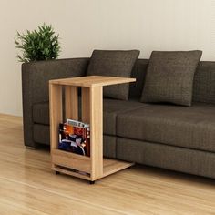 a small wooden table sitting on top of a hard wood floor next to a couch