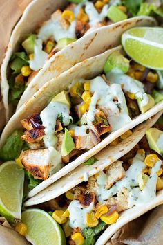 three tacos with chicken, corn and avocado