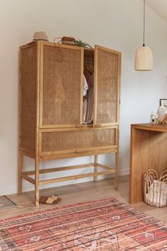 a wooden cabinet sitting next to a rug on top of a hard wood floor in a living room