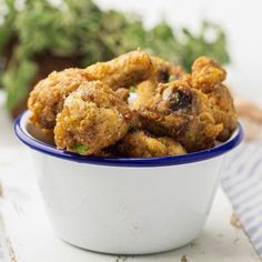 a white bowl filled with fried food on top of a table