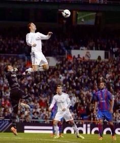 two soccer players colliding for the ball in front of an audience